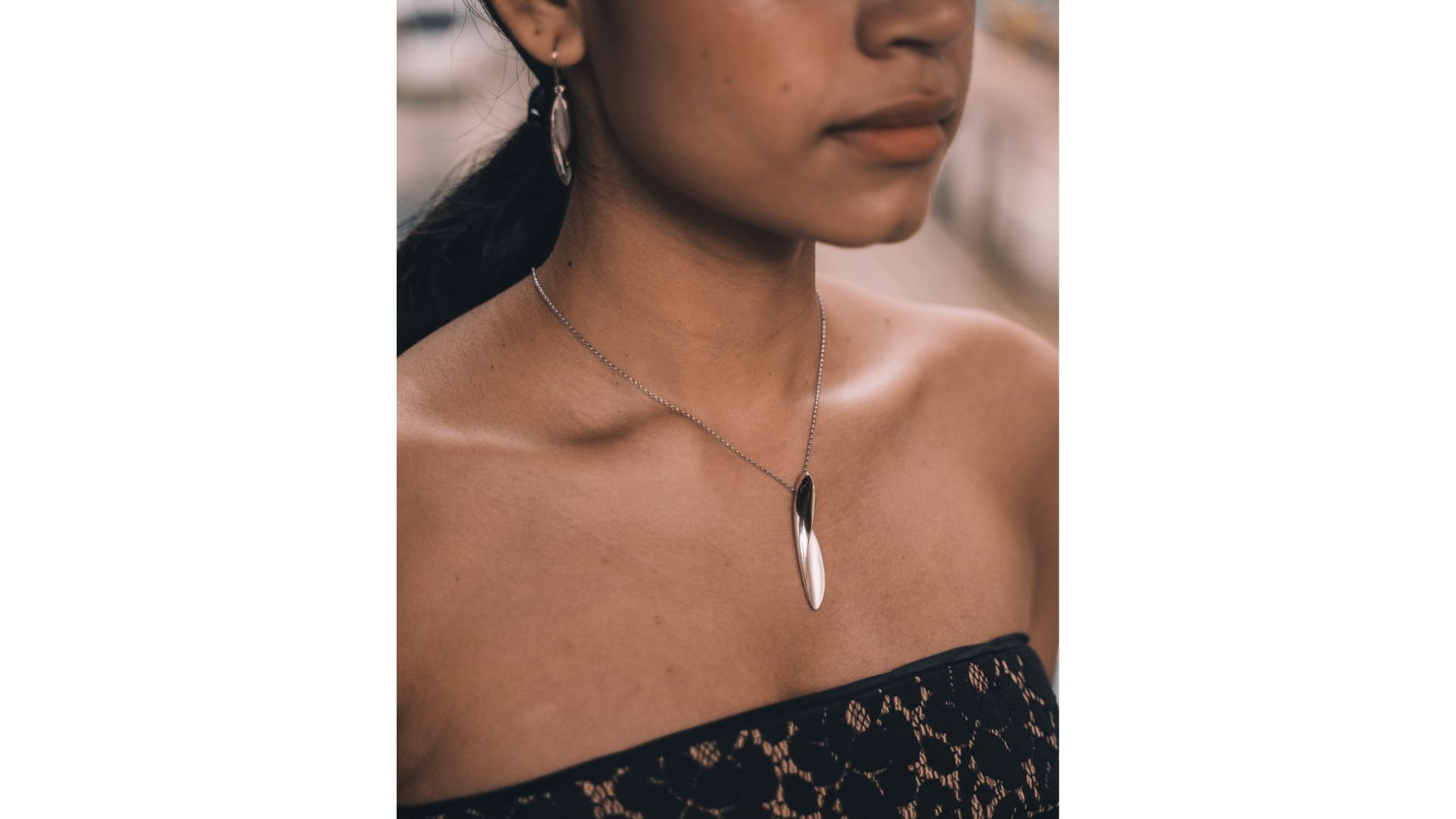 A person wearing a necklace

Description automatically generated