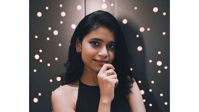 A person with her hand on her chin

Description automatically generated