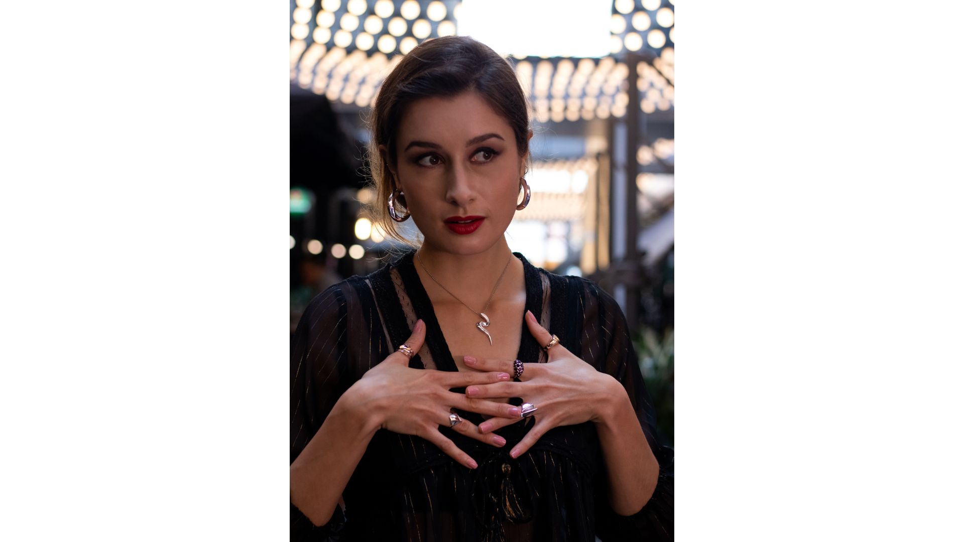 A person with her hands on her chest
Description automatically generated