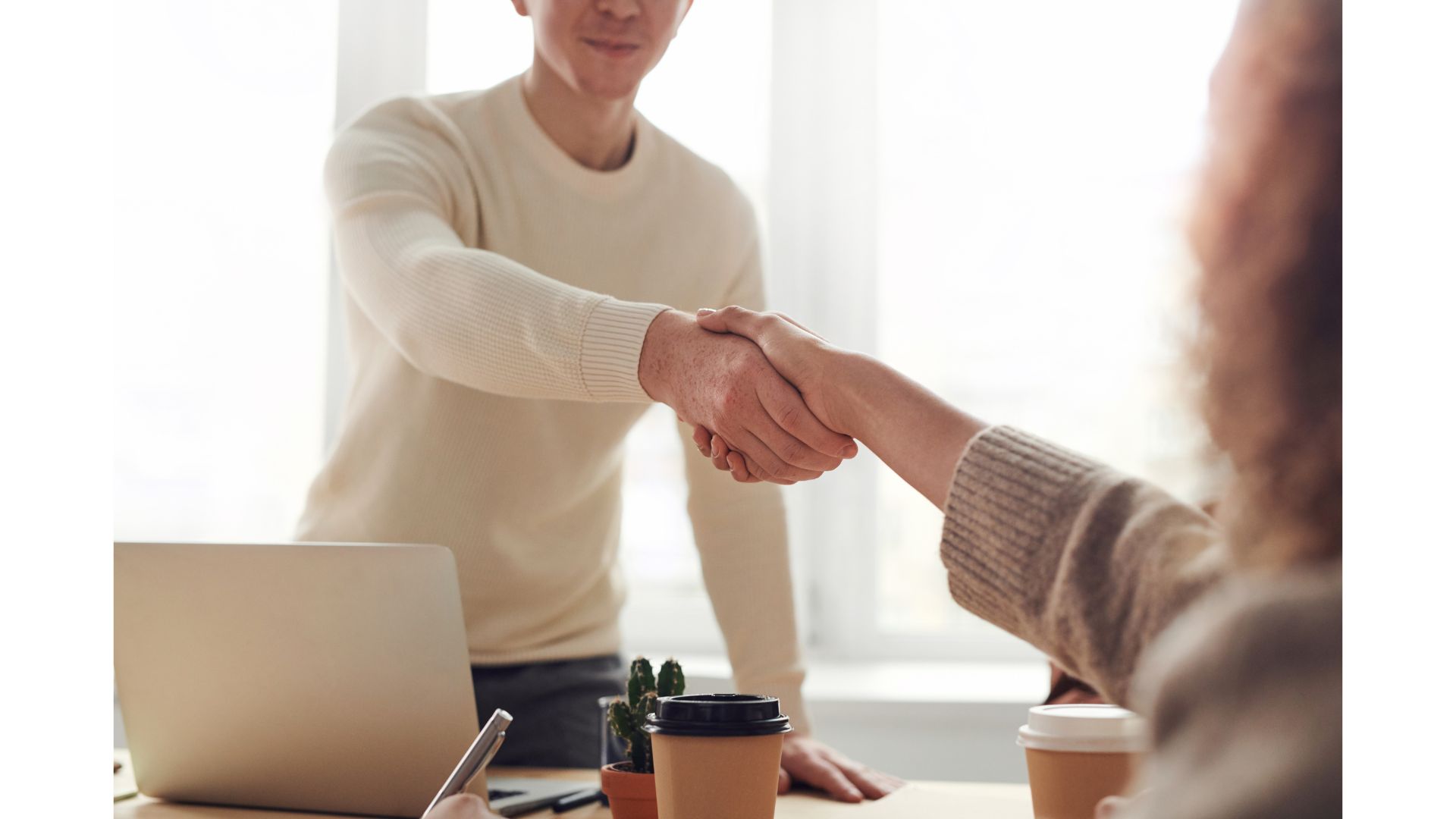 A person and person shaking hands
Description automatically generated