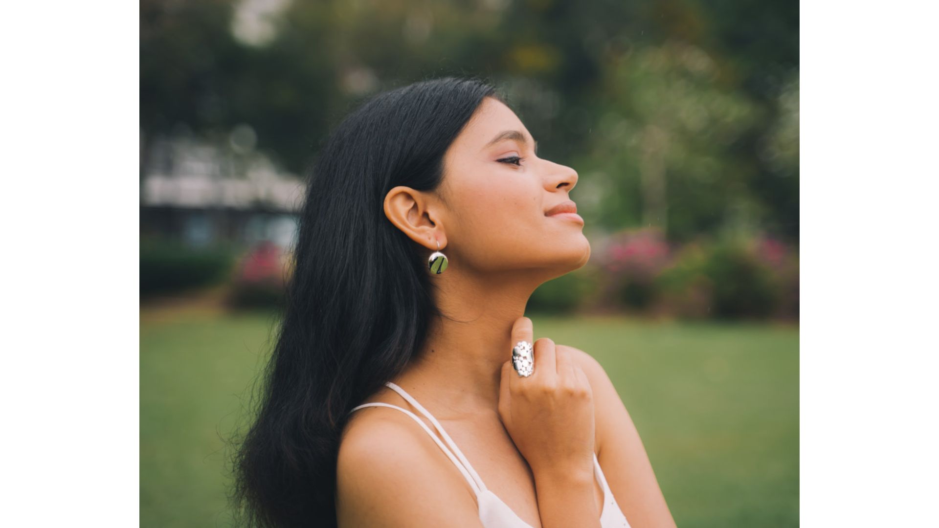 A person with her hand on her neck

Description automatically generated