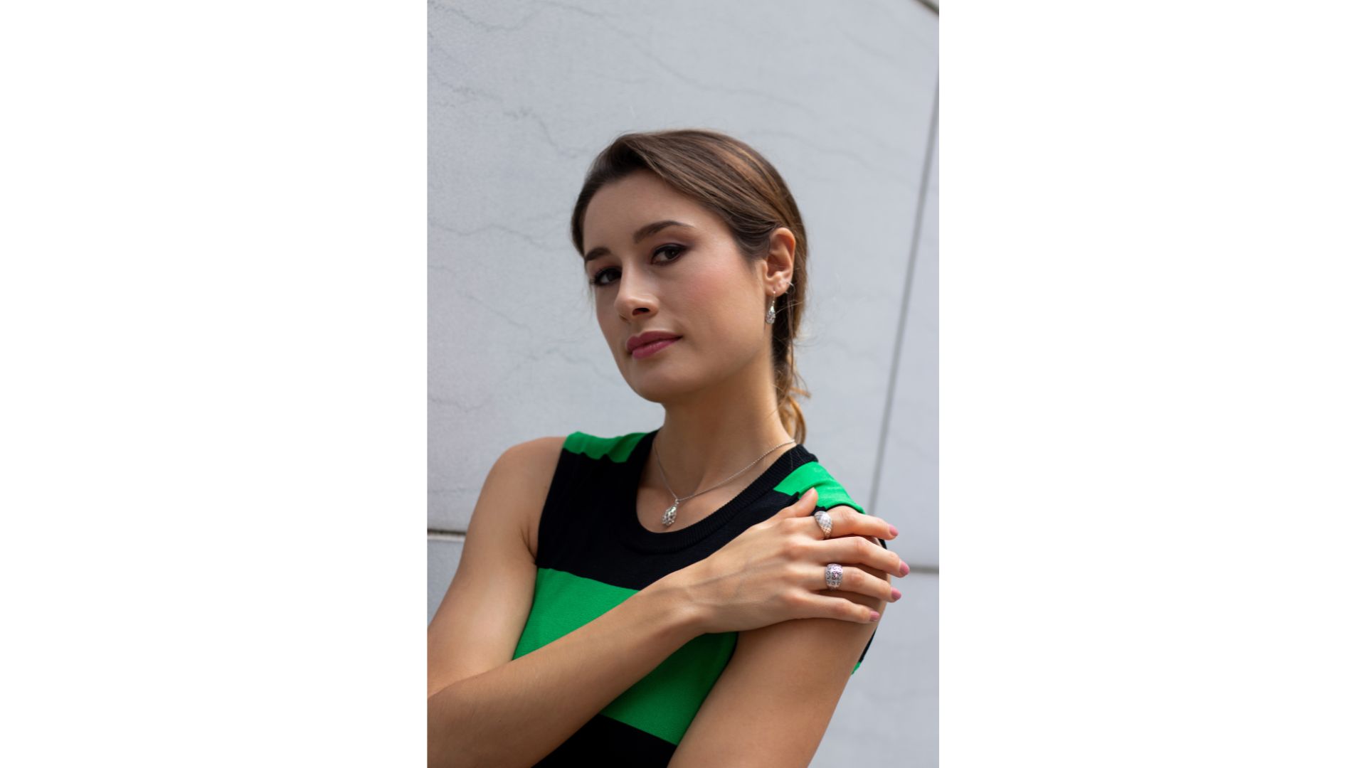 A person with her hand on her shoulder

Description automatically generated