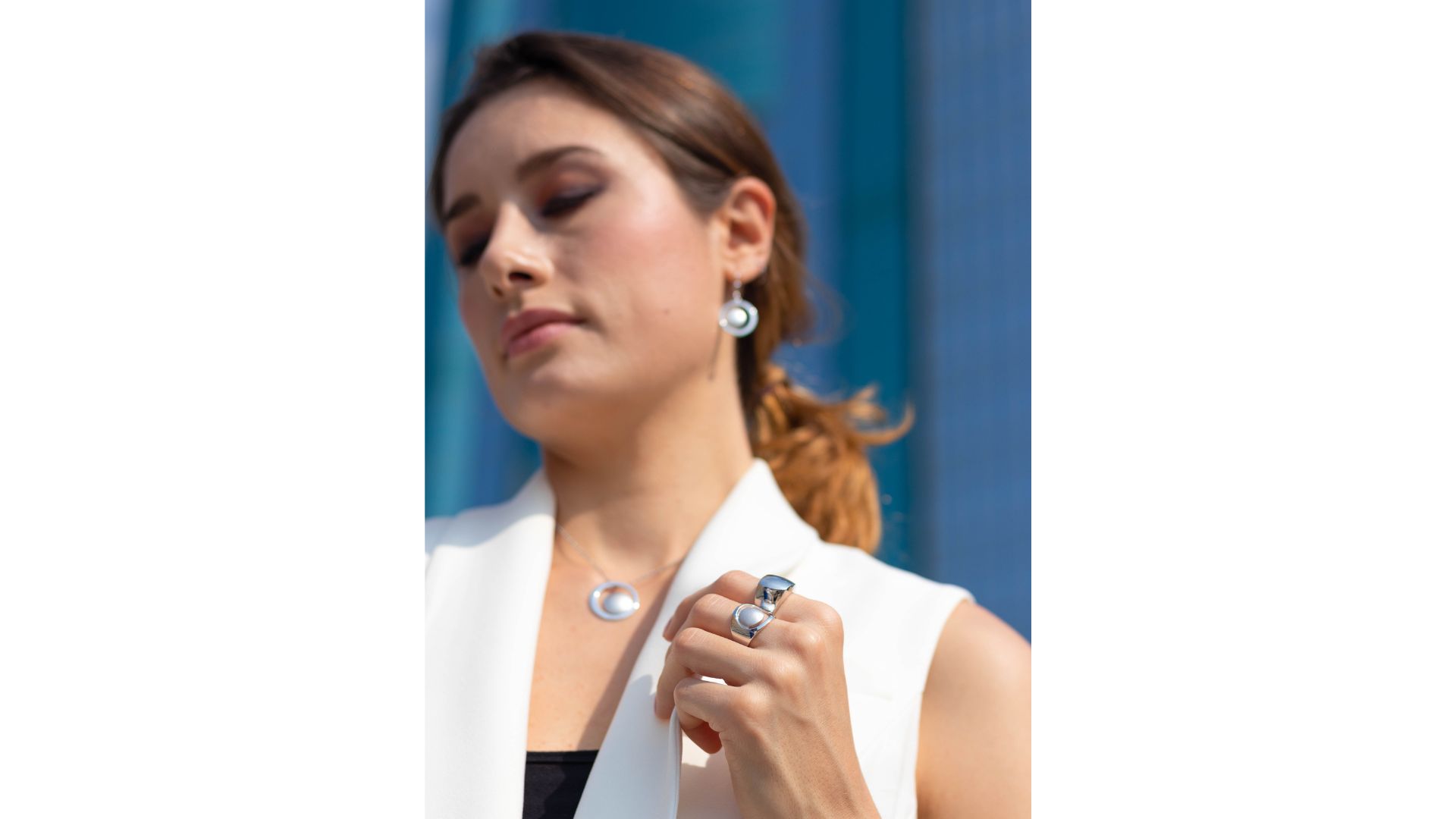 A person wearing a white jacket and earrings

AI-generated content may be incorrect.