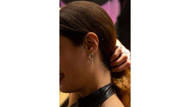 A person with earrings on her ear

Description automatically generated