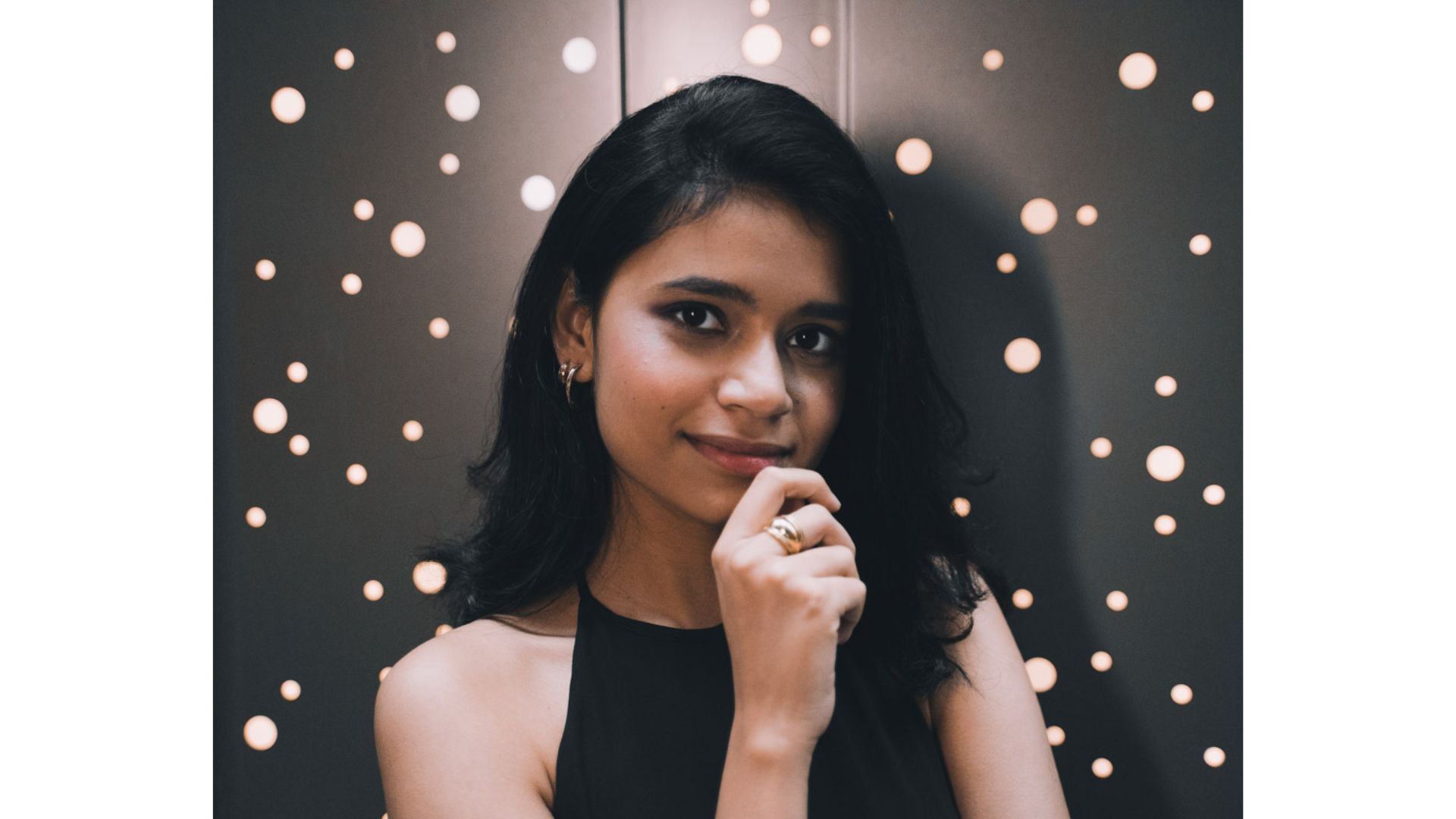 A person with her hand on her chin
Description automatically generated
