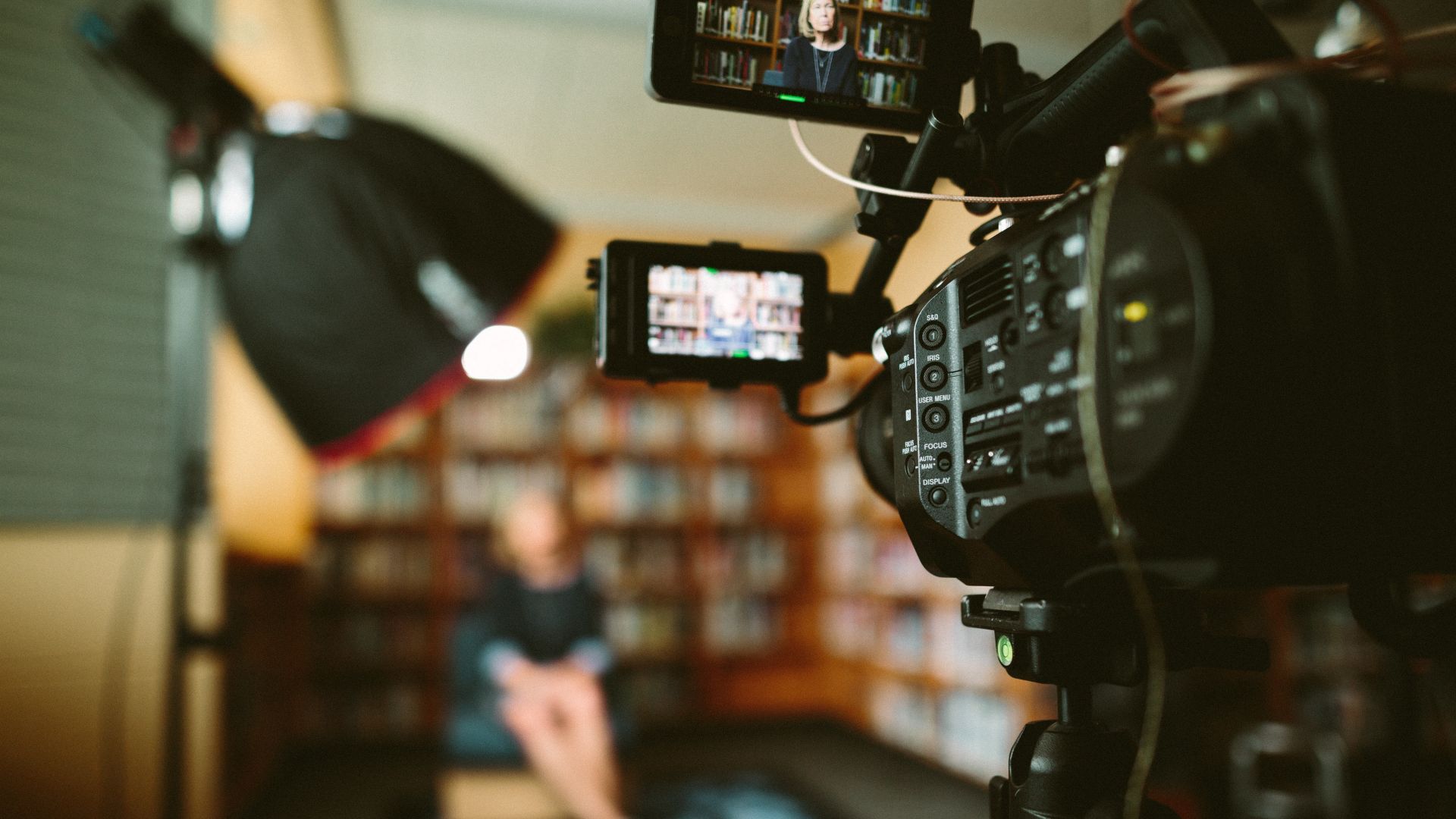 A camera with a screen and a person in the background
AI-generated content may be incorrect.