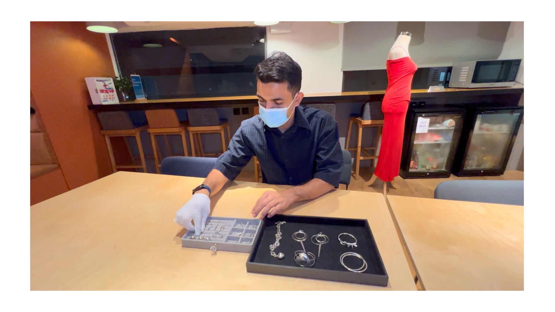 A person wearing a mask and gloves sitting at a table

AI-generated content may be incorrect.