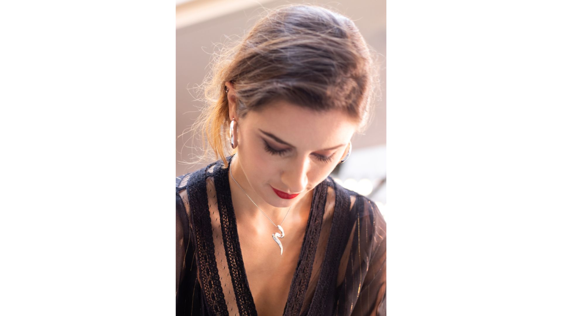 A person looking down with her earring
Description automatically generated