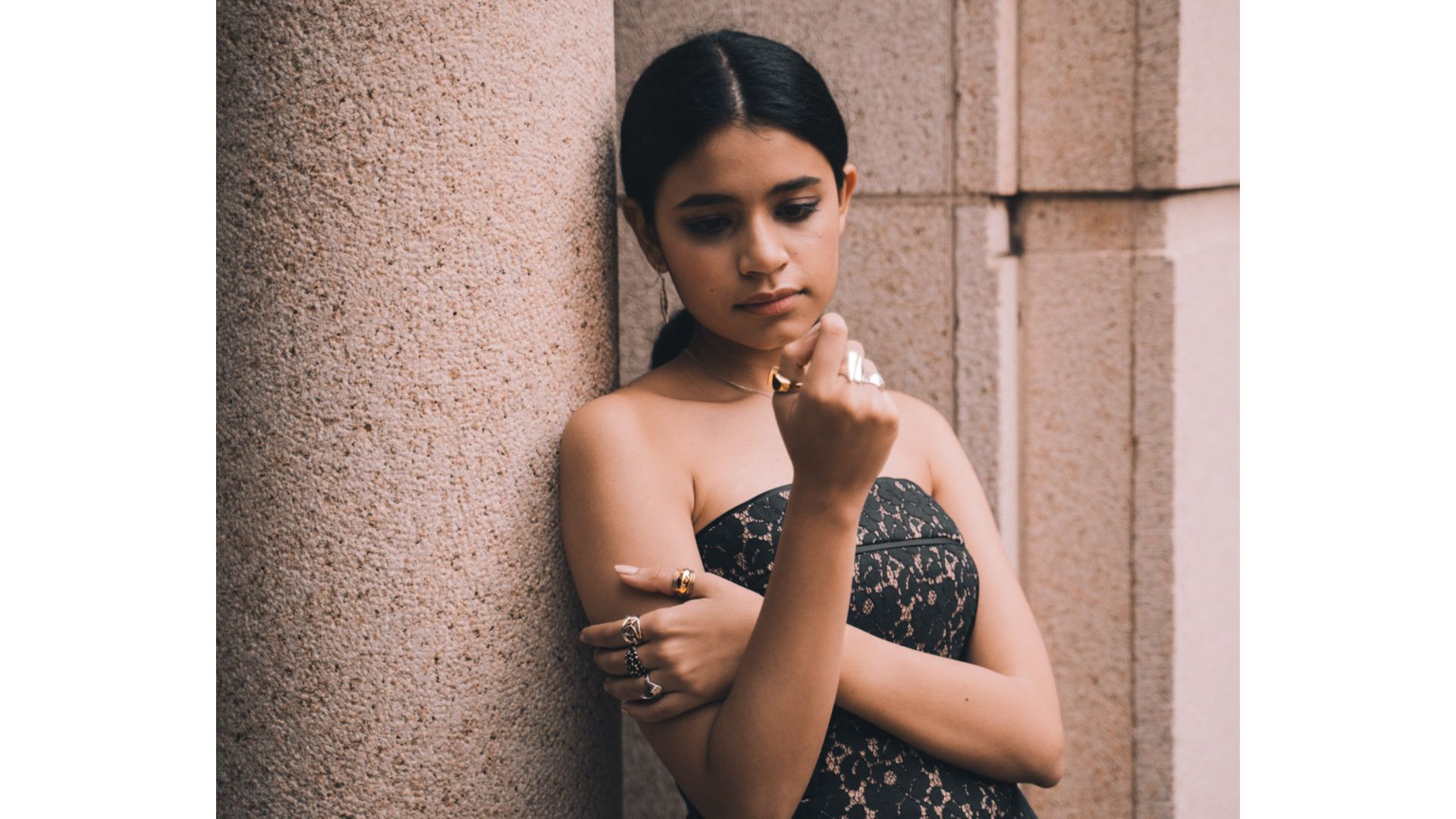 A person leaning against a wall

Description automatically generated
