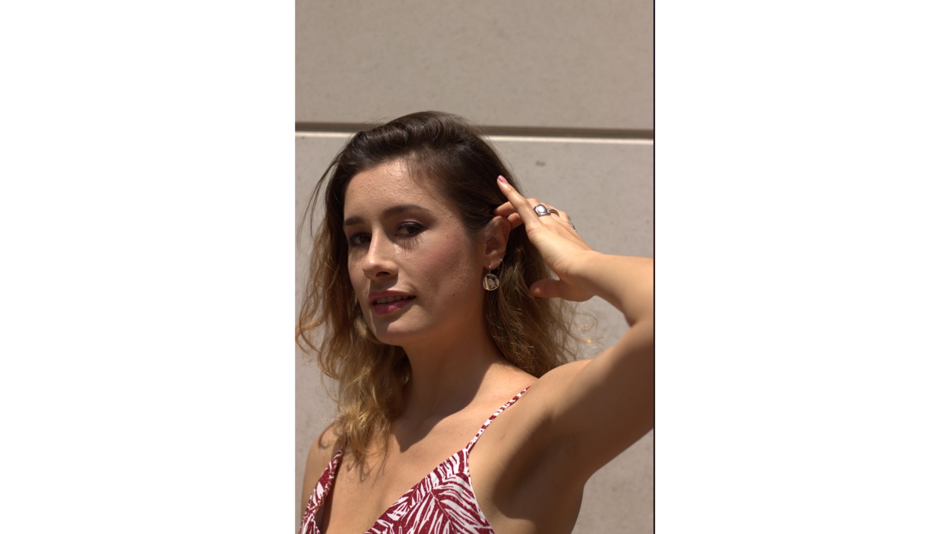 A person touching her hair

Description automatically generated