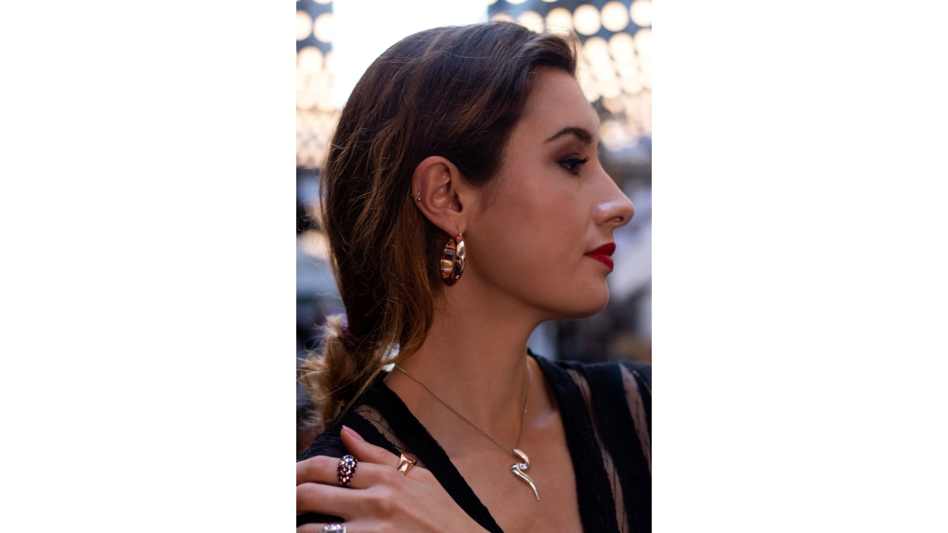 A person with her hand on her shoulder
Description automatically generated
