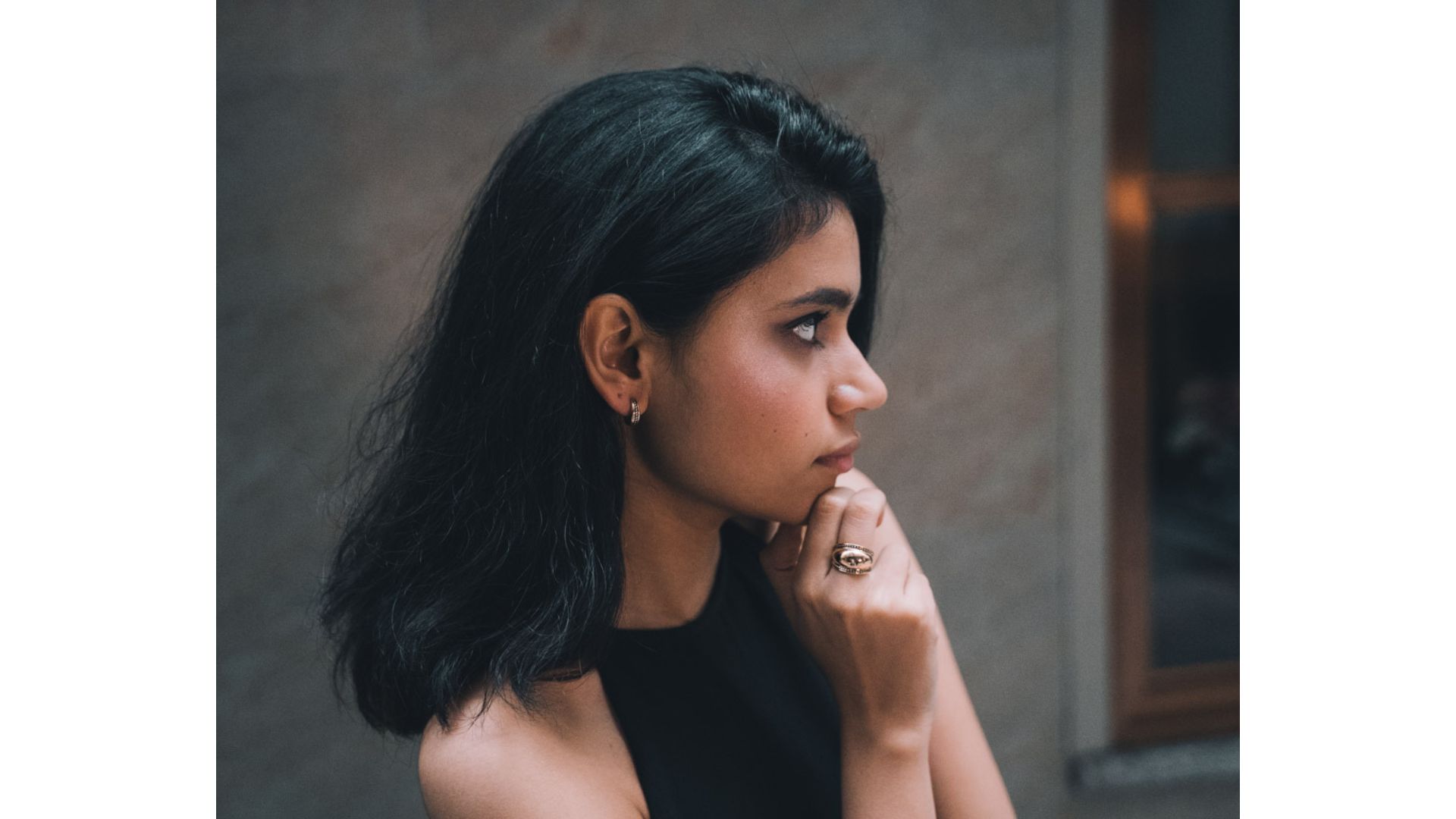 A person with her hand on her chin

Description automatically generated