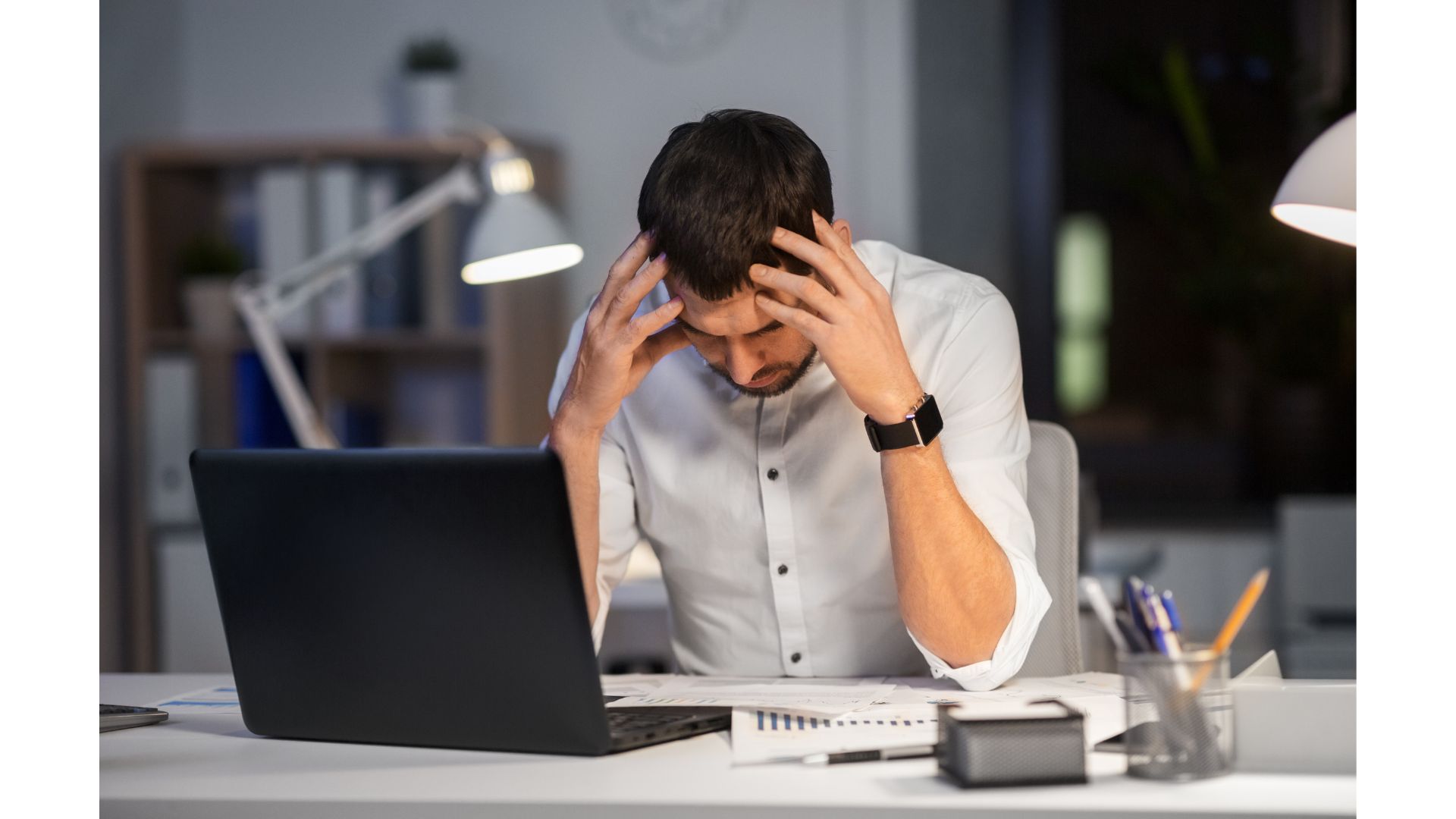 A person holding his head in front of a computerundefinedundefinedundefinedundefinedAI-generated content may be incorrect.