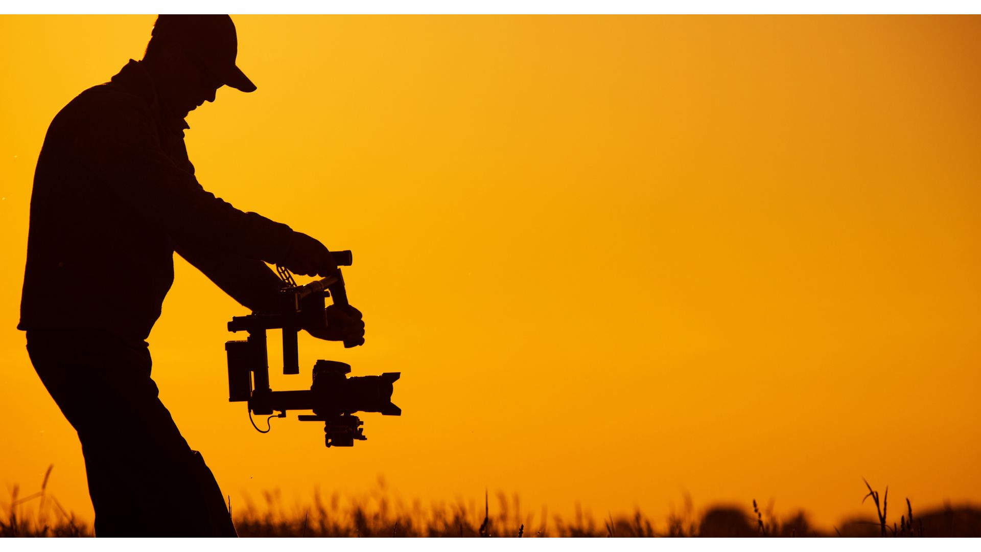 A silhouette of a person holding a cameraundefinedundefinedundefinedundefinedDescription automatically generated