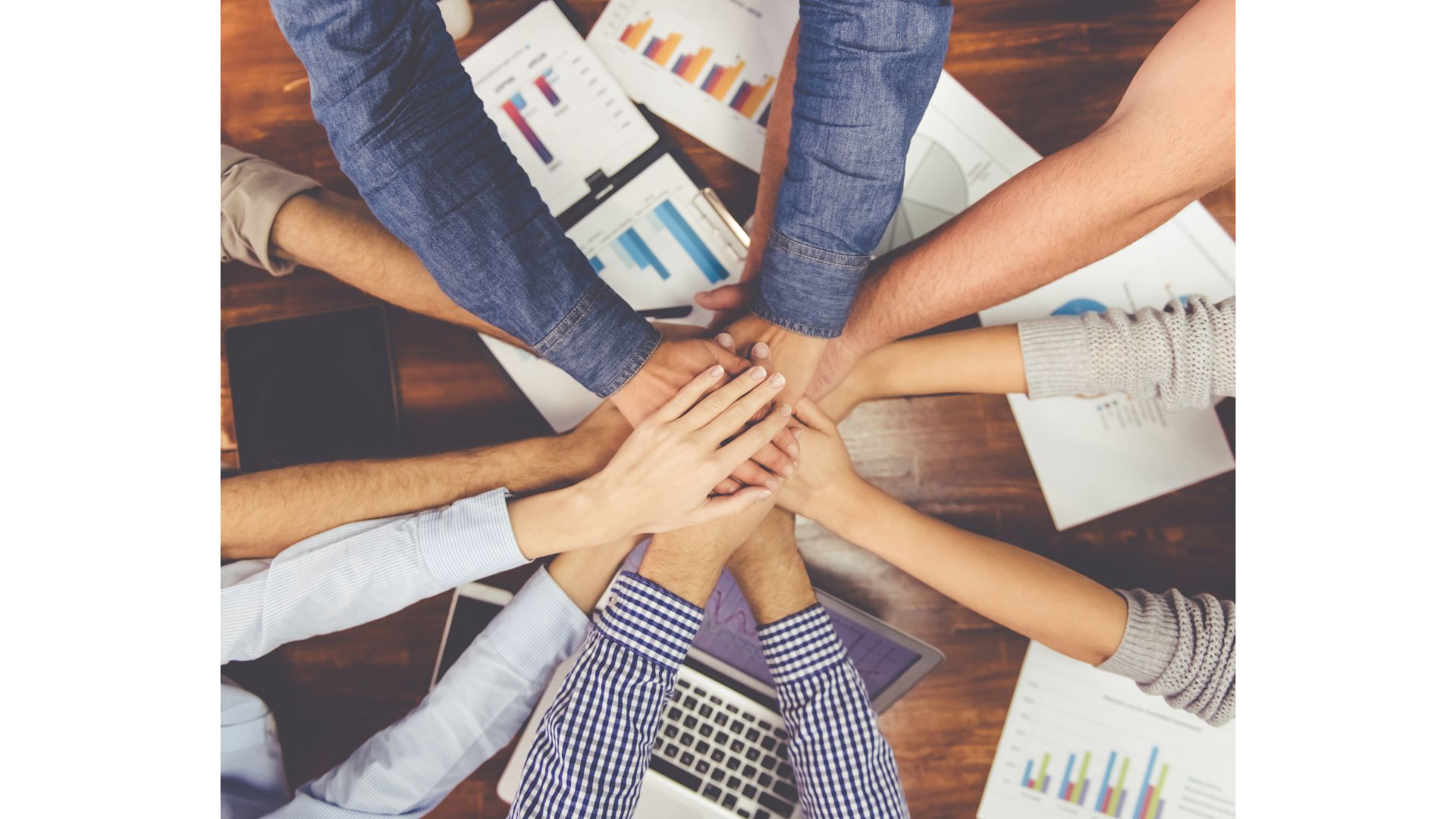 A group of people putting their hands togetherundefinedundefinedundefinedundefinedDescription automatically generated